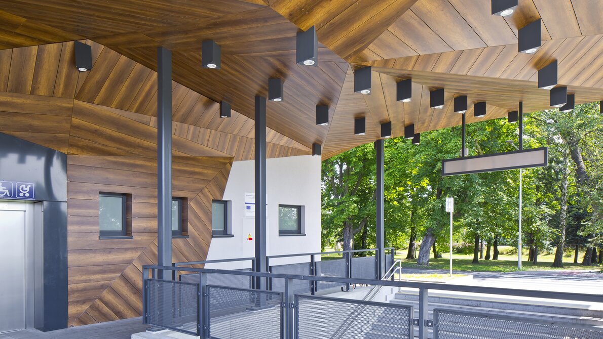 Ein moderner Bahnhof mit holzverkleideten Designelementen und Beleuchtung.