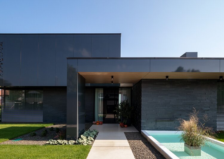 Fundermax Privathaus mit glänzender Fassade aus Max Compact Exterior in den Dekoren 0070 und 0742 sowie in der Oberfläche NG