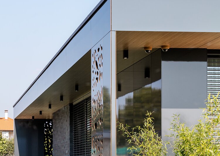 Fundermax Privathaus mit glänzender Fassade aus Max Compact Exterior in den Dekoren 0070 und 0742 sowie in der Oberfläche NG