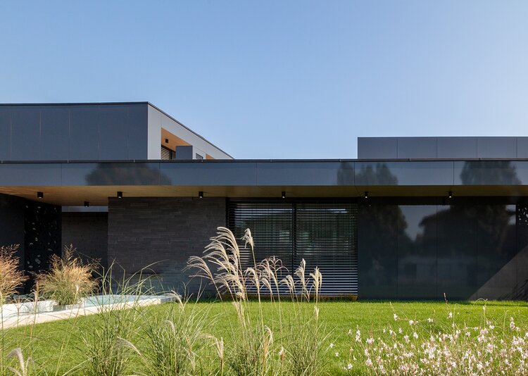 Fundermax Privathaus mit glänzender Fassade aus Max Compact Exterior in den Dekoren 0070 und 0742 sowie in der Oberfläche NG