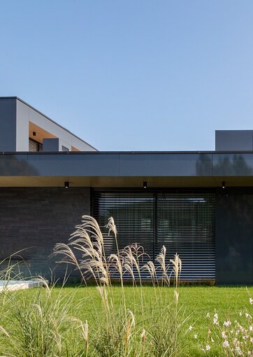 Fundermax Privathaus mit glänzender Fassade aus Max Compact Exterior in den Dekoren 0070 und 0742 sowie in der Oberfläche NG