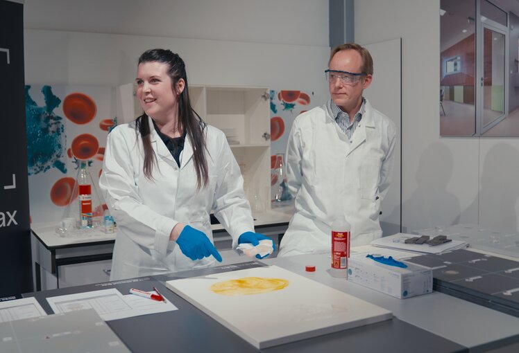 Lab Academy in Wiener Neudorf: Julia Kadnar und Hubertus Burger-Scheidlin demonstrieren, wie sich Laboroberflächen einfach reinigen lassen.  | © Felix Wagner